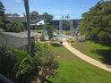 Scenic view of the community pool area surrounded by lush greenery and multiple buildings with blue roofs at 6142 7Th Ave W # 6142, Bradenton, FL 34209