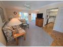 Comfortable living room with ceiling fan, carpeted floors, and a view into the adjacent kitchen area at 6142 7Th Ave W # 6142, Bradenton, FL 34209