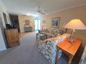 Cozy living room with carpeted floors, floral sofas, blue entry door, and decorative furnishings at 6142 7Th Ave W # 6142, Bradenton, FL 34209