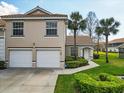 Inviting townhome featuring a two-car garage, tile roof, manicured landscaping, and a charming front entrance at 7157 Strand Cir # 24-102, Bradenton, FL 34203