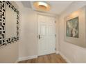 Inviting entryway showcasing a front door with modern light fixture and decorative mirror at 800 N Tamiami Trl # 312, Sarasota, FL 34236