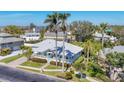 Captivating aerial view of a charming coastal home with a gray roof, lush landscaping, and a picturesque neighborhood at 8012 18Th W Ave, Bradenton, FL 34209