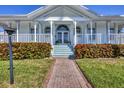 Inviting front porch with classic white columns and steps, framed by lush landscaping and brick pathway at 8012 18Th W Ave, Bradenton, FL 34209