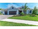 Attractive single-story home featuring a three-car garage, stone accents, and a well-maintained lawn at 8046 Anthirium Loop, Sarasota, FL 34240