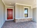 Inviting covered front porch with brick accents, providing a welcoming entryway to the home at 8046 Anthirium Loop, Sarasota, FL 34240