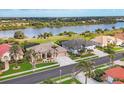 Beautiful aerial view of a home in a waterfront community with lush greenery and scenic views of a lake at 854 Dahoon Cir, Venice, FL 34293