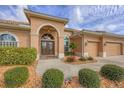 Stunning home featuring manicured landscaping, a paver walkway and a stately double door entry at 854 Dahoon Cir, Venice, FL 34293