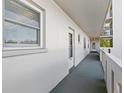 Exterior building hallway featuring white walls and neutral-toned carpet, with access to multiple units at 3660 Ironwood Cir # 205M, Bradenton, FL 34209