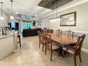 Dining room with decorative tray ceiling, wooden table, and views of the kitchen and living room at 12151 Amica Loop, Venice, FL 34293