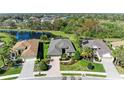 Aerial view of the property with a well-maintained lawn, lake view, and beautiful landscaping at 12263 Lavender Loop, Bradenton, FL 34212