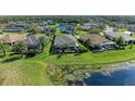 Aerial view of the backyard with a screened enclosure, large backyard, lake, and lush green grass at 12263 Lavender Loop, Bradenton, FL 34212