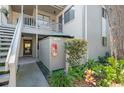 Exterior view of a building featuring a staircase, greenery, and an outdoor storage closet with fire extinguisher at 1620 Boathouse Cir # 101, Sarasota, FL 34231
