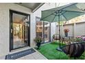 Charming patio area with a table, chairs, an umbrella, and a view through a glass door at 1620 Boathouse Cir # 101, Sarasota, FL 34231