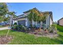 The home's yard boasts flourishing plants, mulch beds and a tidy lawn at 16816 Seraphic Trl, Lakewood Ranch, FL 34211