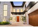 Contemporary home exterior featuring a stone accent wall, modern lighting and a wood-look garage door at 2177 Sunnyside Pl, Sarasota, FL 34239