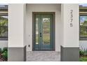 Close-up of a modern home's entrance, showcasing the stylish door, address numbers, and elegant stonework at 2375 Saybrook Ave, North Port, FL 34286