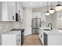 An airy kitchen showcases stainless appliances, white cabinets and quartz countertops at 2375 Saybrook Ave, North Port, FL 34286