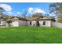 Charming single-story home with a well-manicured lawn, white shutters, a paver driveway, and a two car garage at 3266 Lanai Ave, North Port, FL 34288