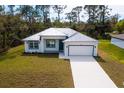 Picture-perfect single-story home with a lovely yard, modern architectural details, and an attached two-car garage at 3807 Las Vegas Ave, North Port, FL 34288