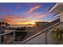 Stunning sunset view from the balcony overlooking the ocean and lush tropical landscape in this coastal home at 3916 N Shell Rd, Sarasota, FL 34242