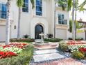 Beautiful front entrance with a fountain, red brick accents, and tropical landscaping at 4129 Roberts Point Cir, Sarasota, FL 34242