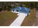 Aerial view of a modern, single-story home with a metal roof and long driveway at 4240 Adelaide Ave, North Port, FL 34288