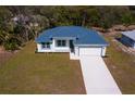 An aerial view of a modern, single-story home with a metal roof, long driveway, and well-maintained landscaping at 4240 Adelaide Ave, North Port, FL 34288