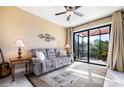 Cozy living room with plush sofa, ceiling fan, and access to the screened patio at 4386 Library St, Port Charlotte, FL 33948
