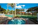 Community hot tub is surrounded by lounge chairs and adjacent to the tennis court at 4425 45Th W Ave # 101, Bradenton, FL 34210