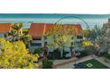 Exterior view of a multi-story home with a red tile roof and lush landscaping at 4535 Bay Club Dr, Bradenton, FL 34210