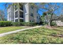 Exterior view of a condo with a well-maintained lawn and garden, enhanced by mature trees and a sidewalk at 5160 Northridge Rd # 302, Sarasota, FL 34238