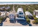 Aerial view of beachfront home with three car garage and manicured lawn surrounded by neighboring homes at 534 Beach Rd, Sarasota, FL 34242