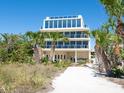 Stunning exterior of multi-story home with private beach access and balconies on each floor at 534 Beach Rd, Sarasota, FL 34242