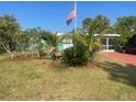 Charming single-story home with lush landscaping, tropical plants, and a vibrant green lawn at 540 Palmetto Ne Dr, Port Charlotte, FL 33952