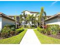 Beautiful condo exterior with lush landscaping, a brick-paved walkway, and elegant architectural details at 5710 Palmer Cir # 203, Bradenton, FL 34211