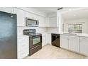 Modern kitchen with black appliances, white cabinets, and quartz countertops at 612 Ironwood Cir # 170, Venice, FL 34292