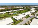 Aerial view of the home in a beautiful community with pool, landscaping, and water views at 6902 8Th W Ave, Bradenton, FL 34209