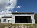 Shows the garage opening of an unfinished one-story home with a metal roof, with cloudy blue skies at 6970 Beckwith Ave, North Port, FL 34291