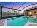 Inviting pool and spa in screened-in lanai, featuring outdoor seating and landscaping views at 7469 Seacroft Cv, Lakewood Ranch, FL 34202