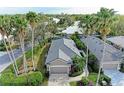 Aerial view showcases the home's gray tile roof, landscaping, and proximity to lush greenery at 8782 49Th E Ter, Bradenton, FL 34211