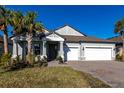 Charming single-story home with a well-manicured lawn, palm trees, and a two-car garage at 922 Fernleaf Run, Bradenton, FL 34212