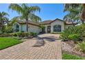 Attractive single-story home featuring a brick driveway and basketball hoop surrounded by landscaping at 110 167Th E Blvd, Bradenton, FL 34212