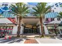 Elegant building entrance featuring tall palm trees, modern art, and clear signage for businesses and residents at 111 S Pineapple Ave # 918, Sarasota, FL 34236