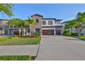Inviting two-story home featuring stone facade, double garage, and a well-maintained front lawn at 11408 Drifting Leaf Dr, Riverview, FL 33579