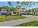 Charming two-story home with stone accents, manicured lawn, palm trees, and a spacious driveway at 11408 Drifting Leaf Dr, Riverview, FL 33579