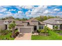 Attractive one-story home features a tile roof, neutral color scheme, verdant landscaping, and an attached garage at 3639 Santa Caterina Blvd, Lakewood Ranch, FL 34211