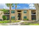 Well-maintained condo featuring exterior stairs and open air entryway, mature trees, and landscaping at 4005 Crockers Lake Blvd # 26, Sarasota, FL 34238