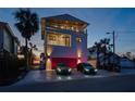 Three-story home with balconies, a two-car garage, and lush landscaping at 412 S Casey Key Rd, Nokomis, FL 34275