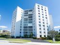 Modern condominium building with multiple floors, green landscaping, and private balconies at 435 S Gulfstream Ave # 601, Sarasota, FL 34236