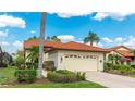 Inviting home featuring a tile roof, a two-car garage, well-maintained landscaping and a neatly manicured lawn at 4909 Clubview E Ct, Bradenton, FL 34203